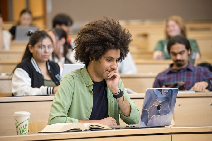 A person looking a laptop in a classroom 