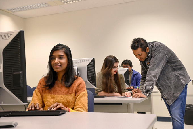 Four people in a computer lab
