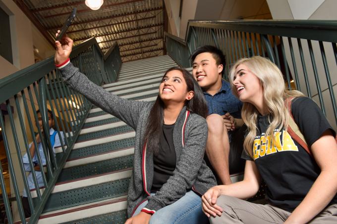 Students taking a group selfie on stairs