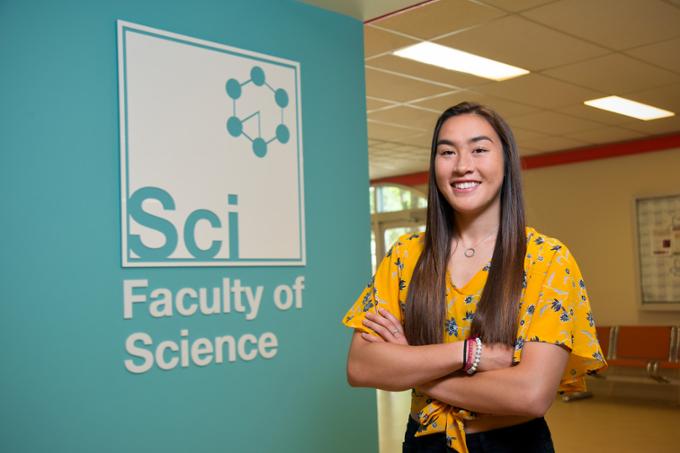 Woman stands by Faculty of Science sign