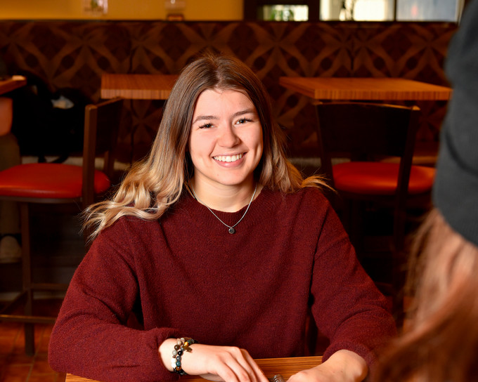 Student poses in a cafeteria