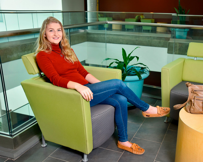 Students pose in a chair