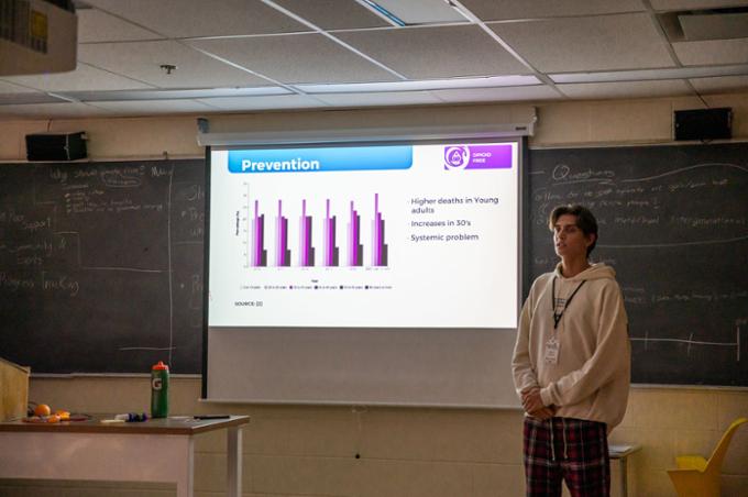 A participant is practicing his pitch presentation in his team's room.