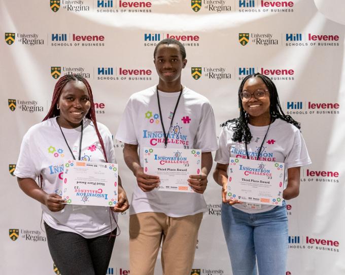 Three members of Team 6 pose for a picture with their certificates.