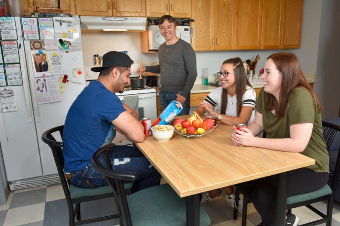 Students sitting around table in residence.