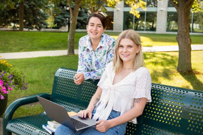 students outdoors with laptop