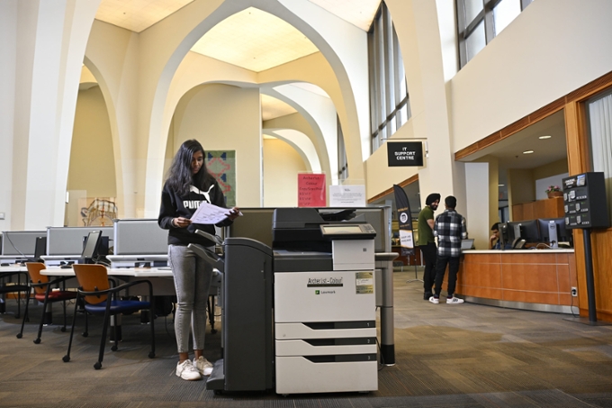 student standing by printer