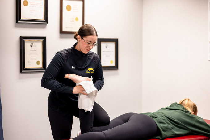 Athletic Therapist treating a patient's leg with manual therapy techniques