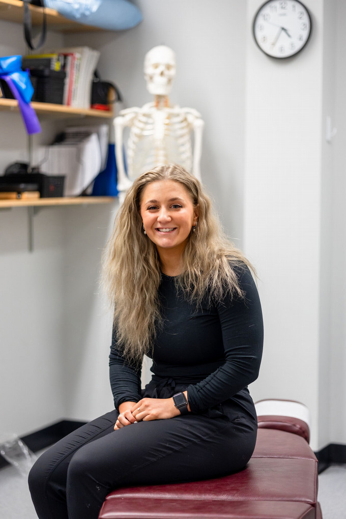 A smiling ] headshot of Dr. Taeganne Galger sitting in her exam room, on her examining table