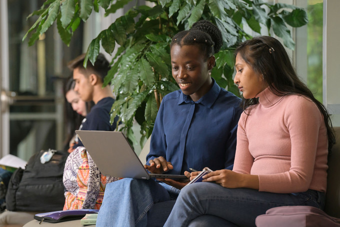 Two students looking at a laptop