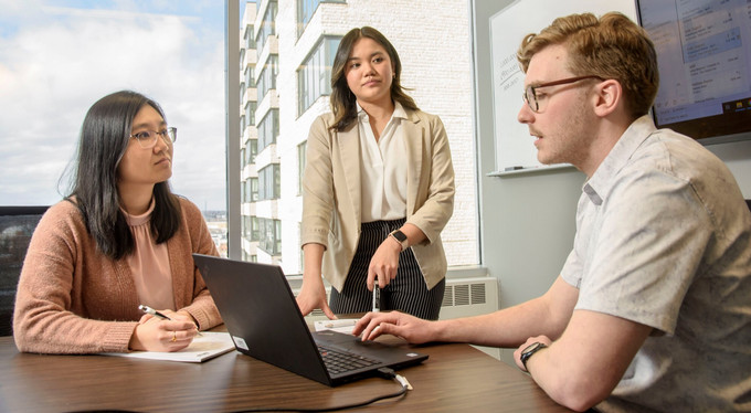 three people in a conference room
