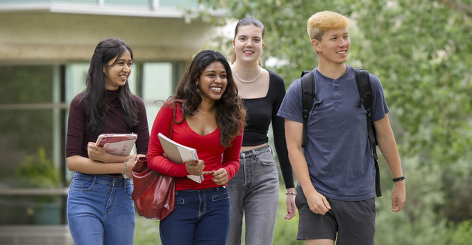 Four people standing and smiling
