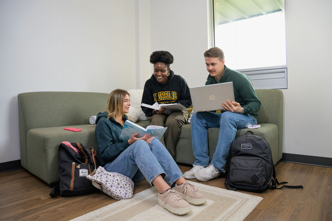 three students sitting and studying