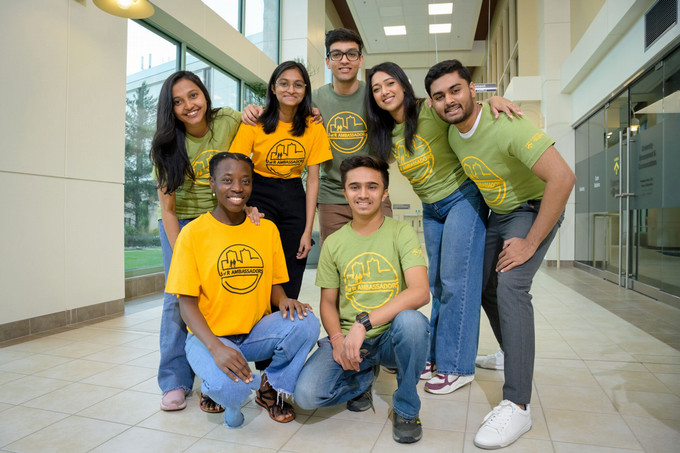 seven people in a hallway smiling