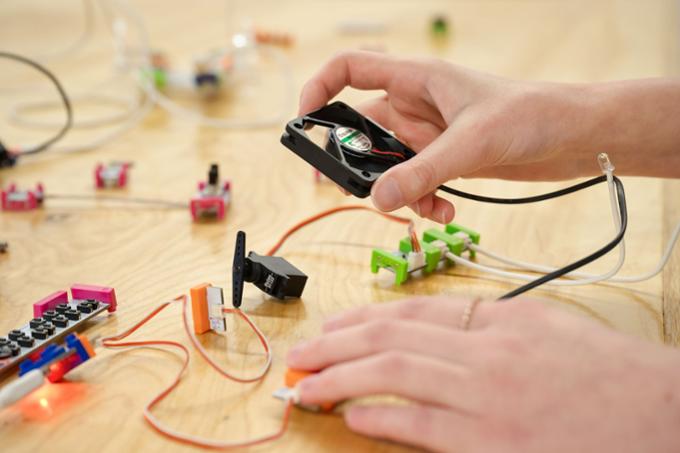 Two hands working on electronic gadgets