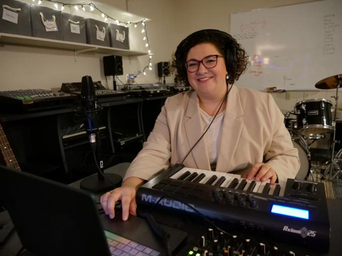 A woman using an electric keyboard and music equipment