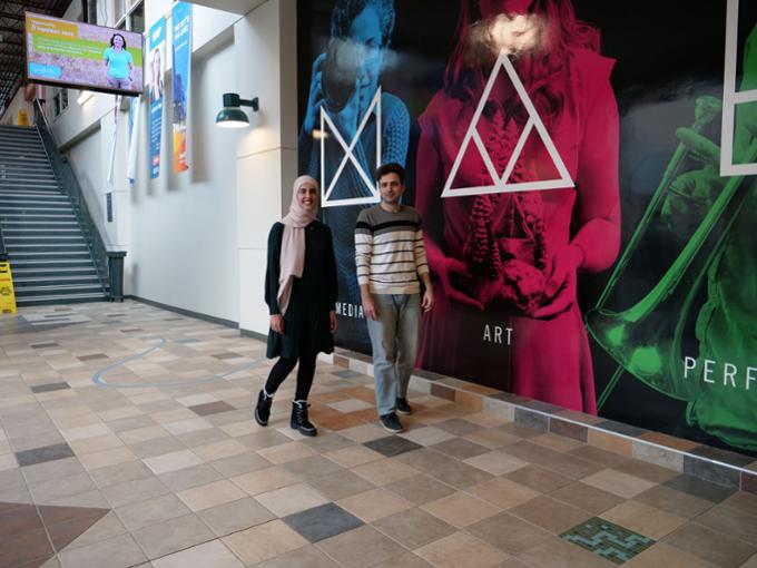 Two students walking in a long hallway