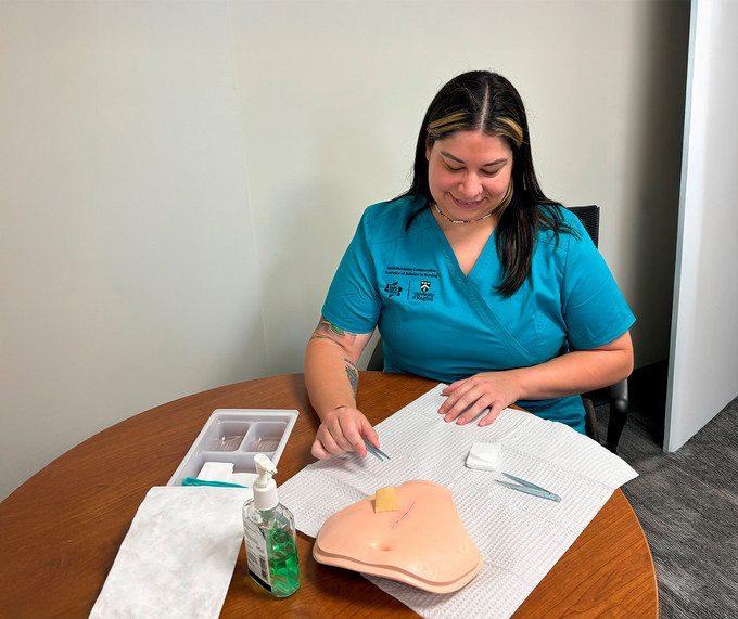 nursing student demonstrating wound closure procedure