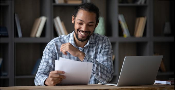 man smiling and looking down at papers