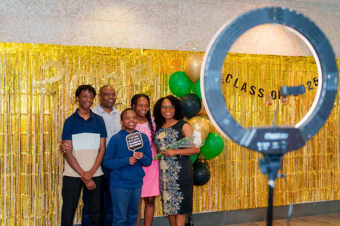 candid photo of a family taking a selfie in front of gold tinseled background 