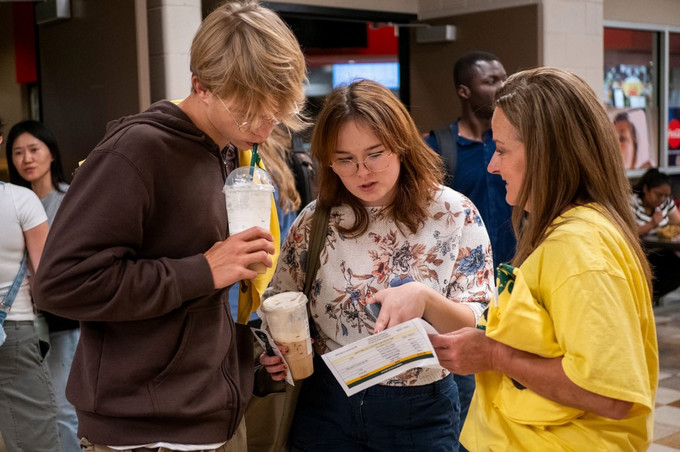 Three people looking at a brochure