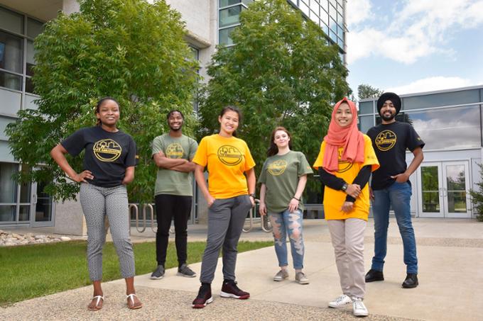 8 UR Ambassadors pose for a photo outside on a summer day.