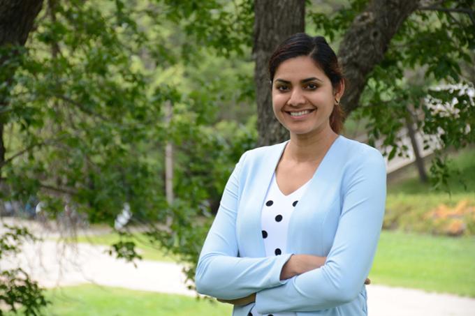 Student standing in front of a tree