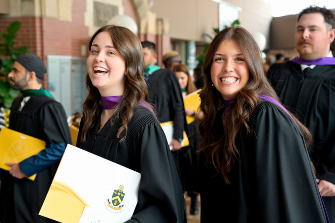 smiling students in convocation gowns