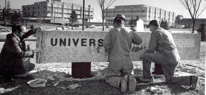 Three men installing a sign