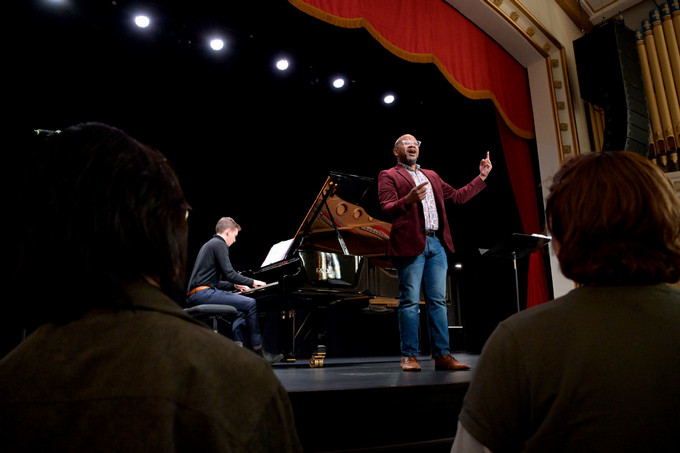 a singer and pianist performing on a stage
