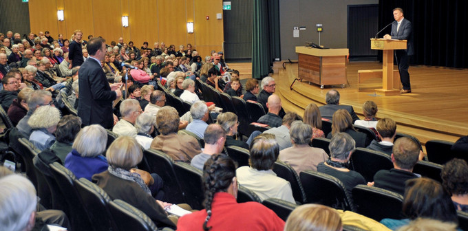 a person giving a lecture to an attentive crowd