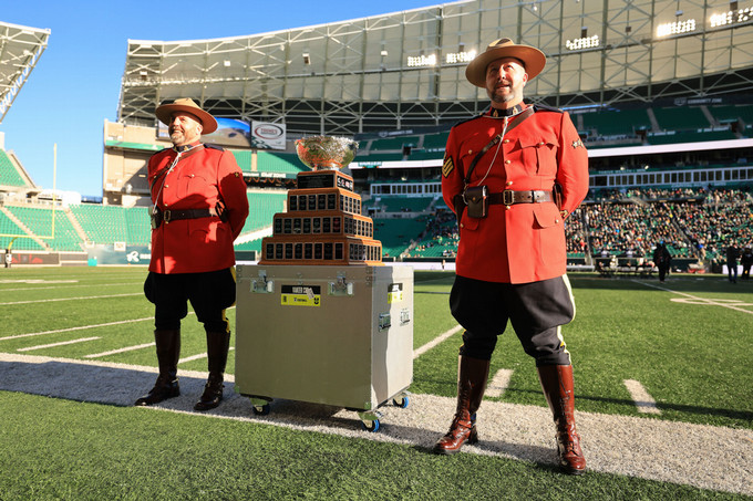 two Mounties pose beside a trophy