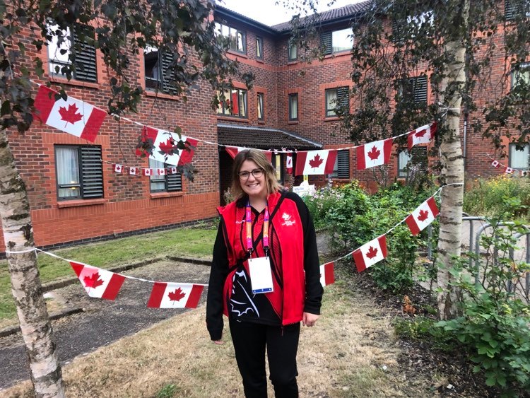 Jordan Kos posing for the camera with Canadian flags all around.