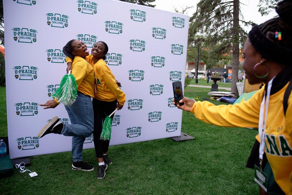 Two smiling students posing for a selfie at the Rams tailgate party.