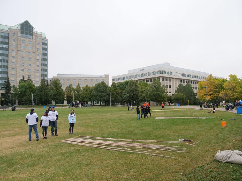 Teams getting set to start raising the tipis.  Credit: University Advancement and Communications. 