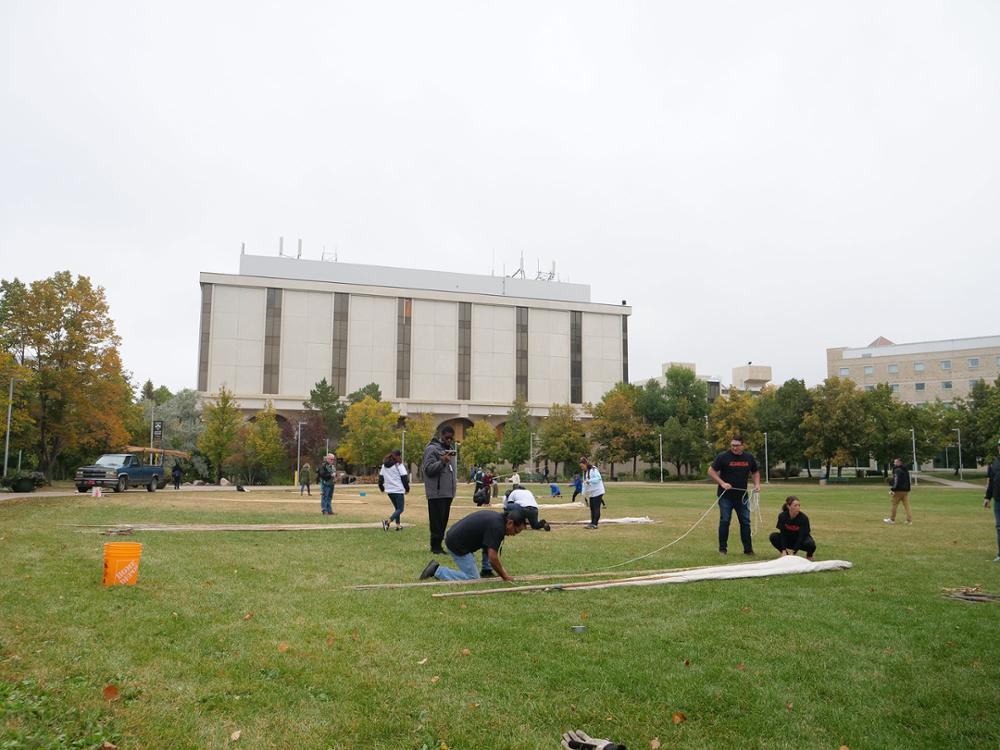 Tying the first two poles. Credit: University Advancement and Communications.