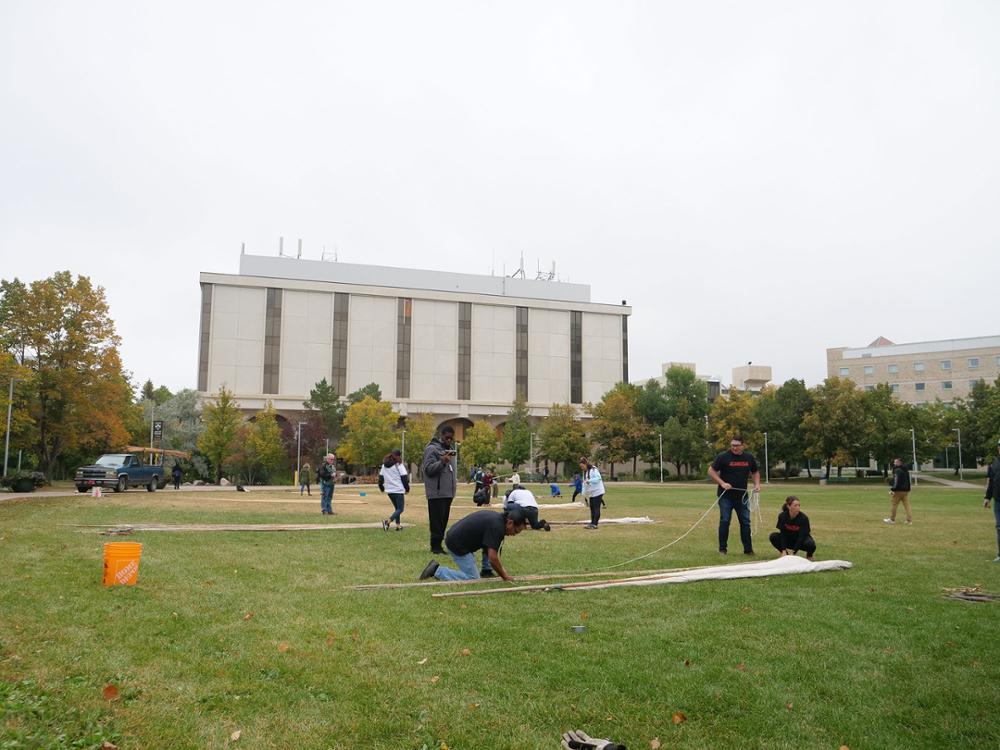 Tying the first two poles. Credit: University Advancement and Communications. 