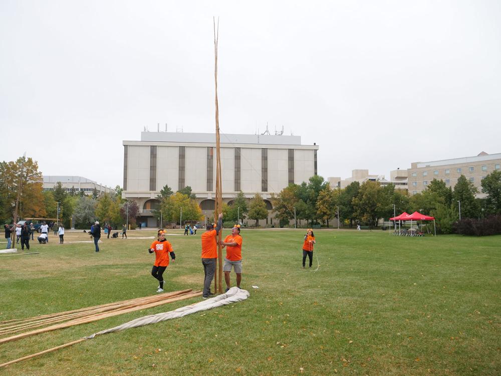 Standing the first two poles. Credit: University Advancement and Communications. 