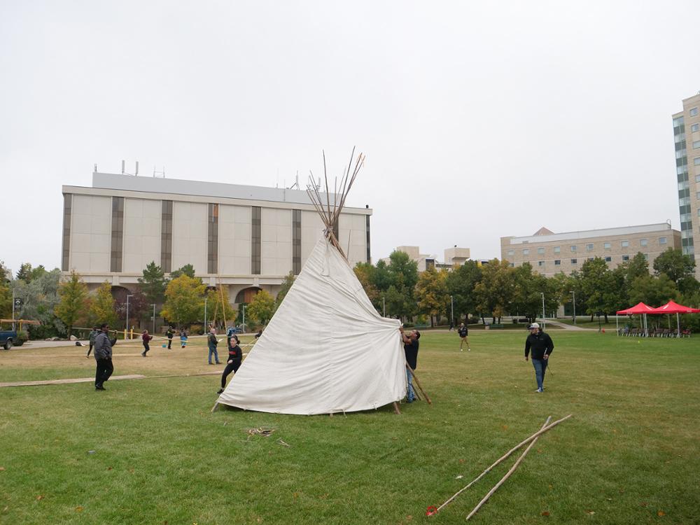 Spreading the tarp. Credit: University Advancement and Communications. 