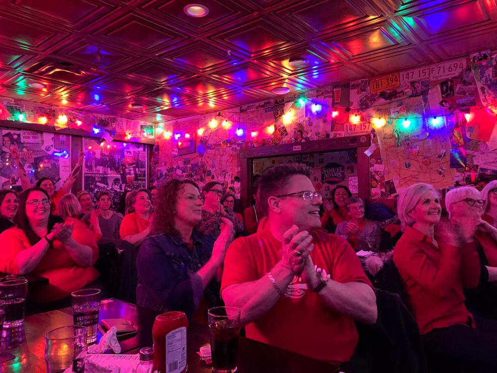 A bar full of people clapping