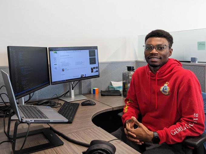 Student sitting at a bank of computer screens