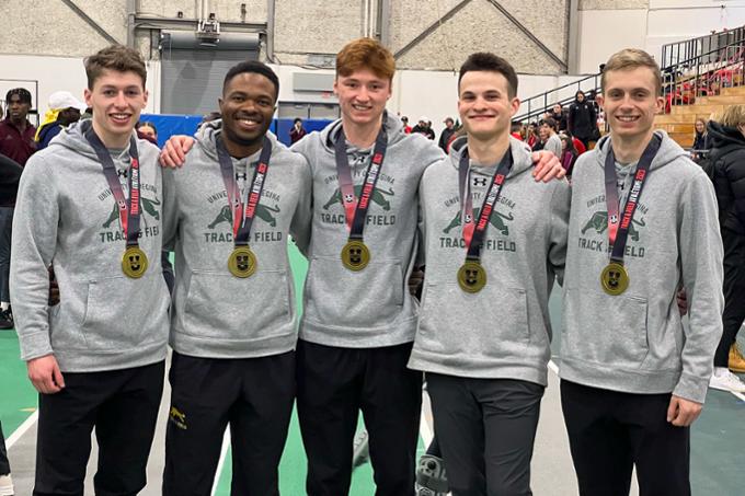 Five athletes posing for a photo together