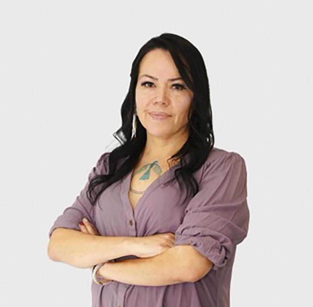 A woman poses for the camera with her arms crossed.