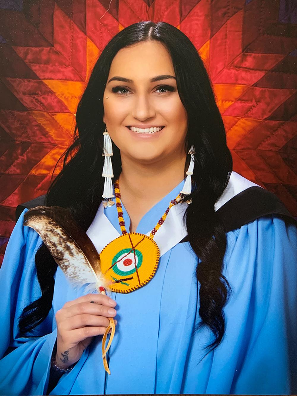 Graduate student posing for the photo in graduation robes