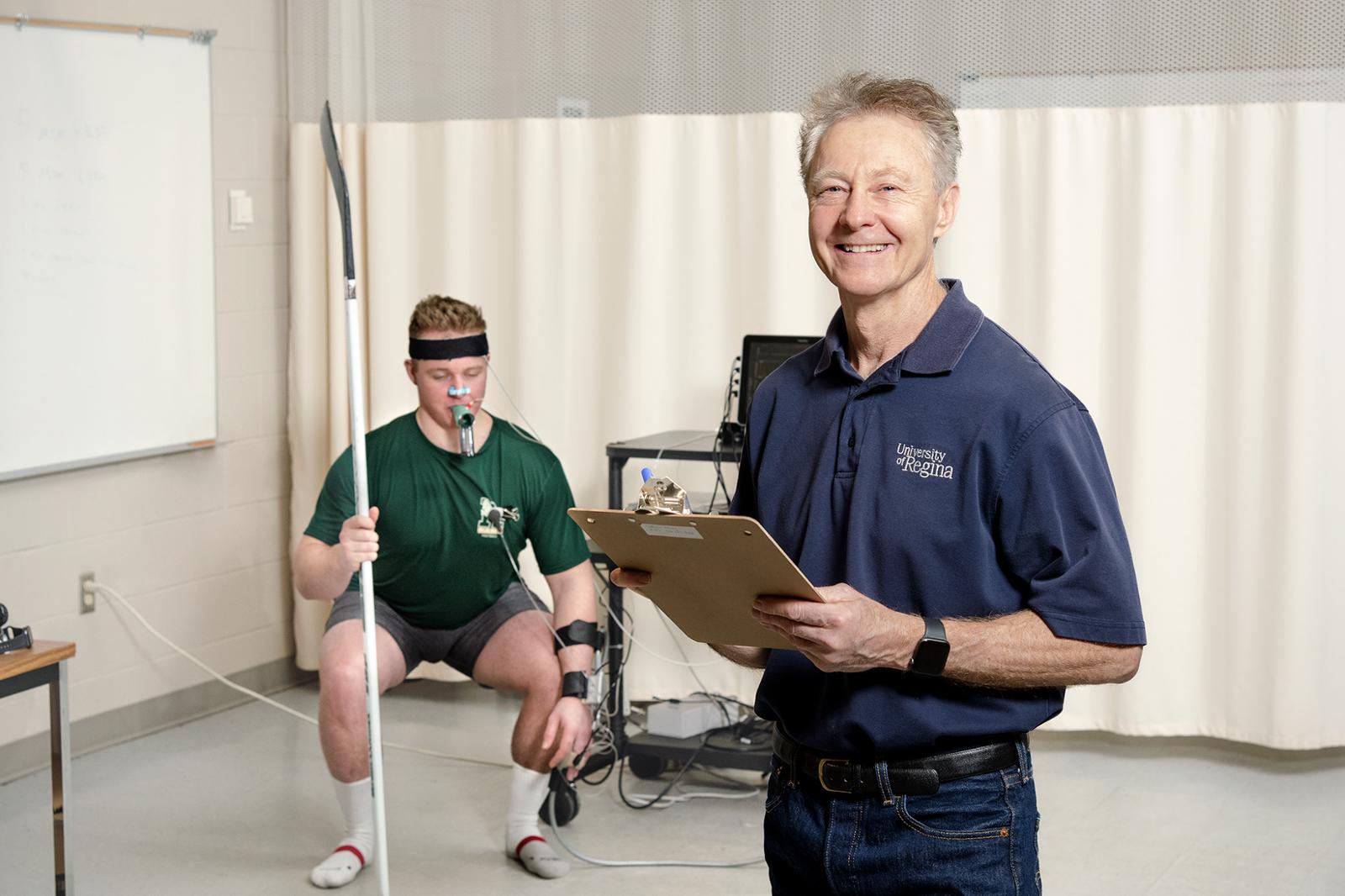 A researcher and a subject in a clinical room with lab equipment around