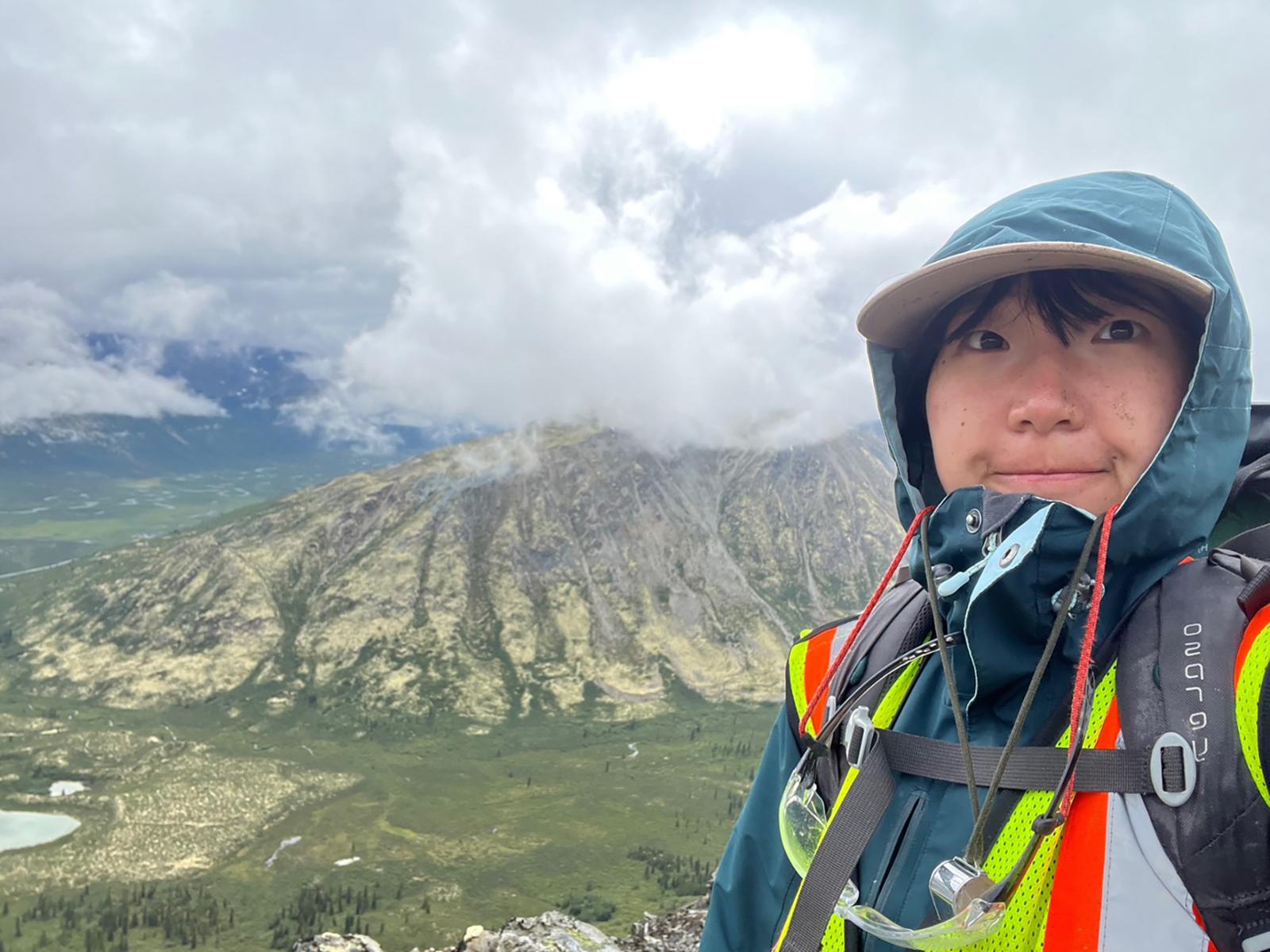 Student takes a selfie on very rugged, rock terrain.