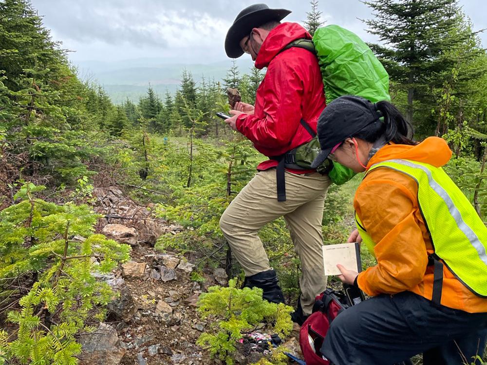 Two students working in the field, examining rocks.