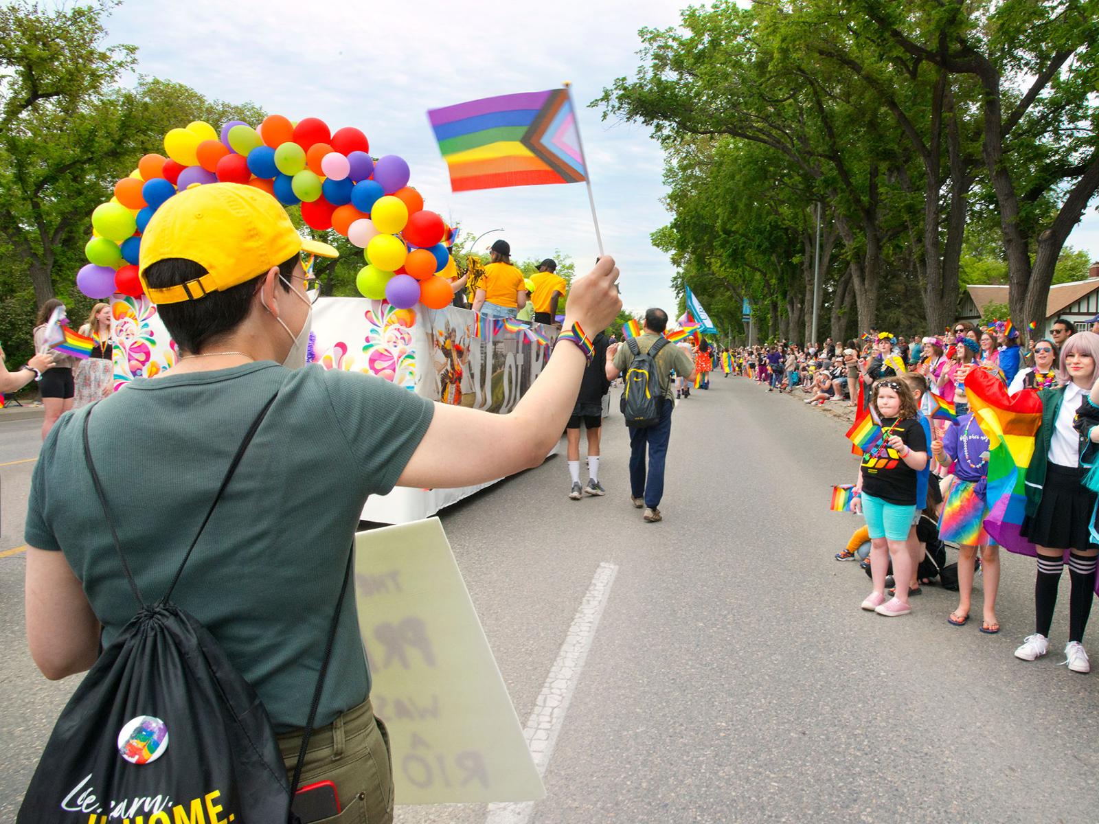 Person walking down the street in a pride parade.