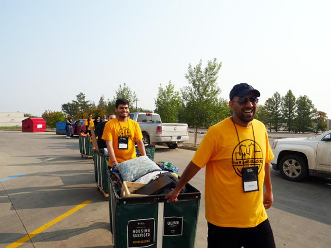 Two students helping other students move in.