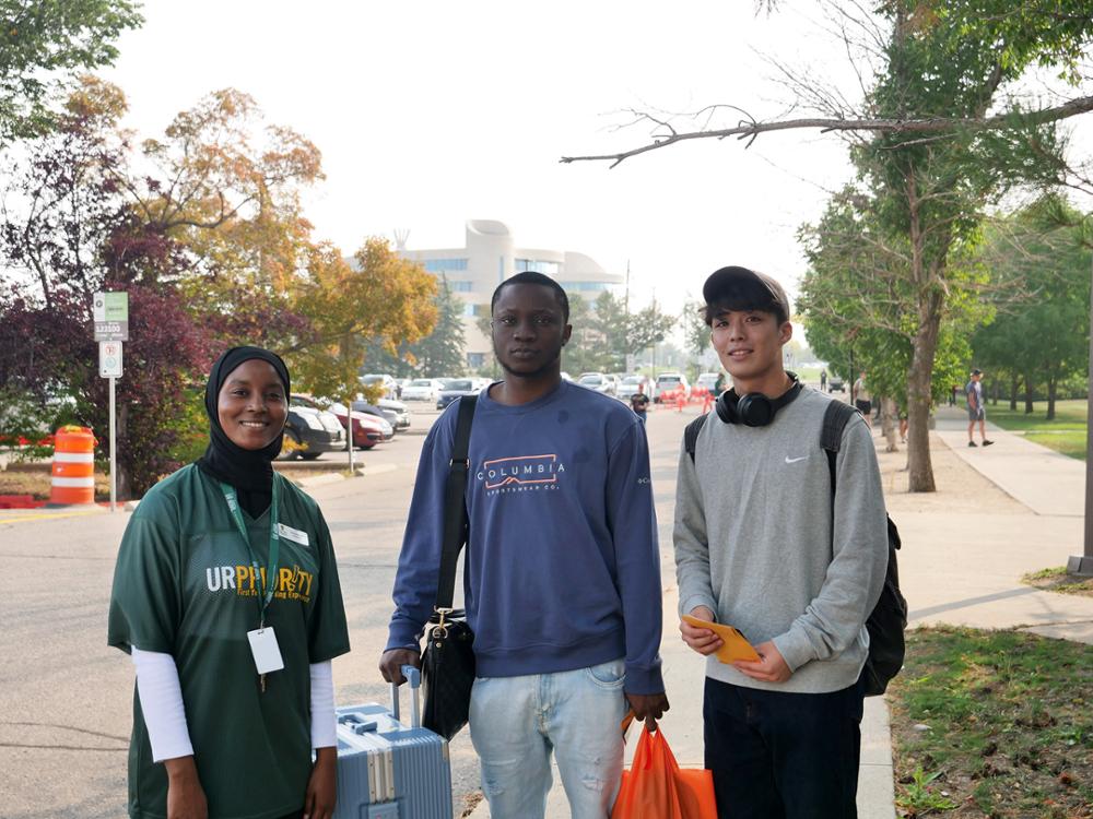 Three students pose on move-in day